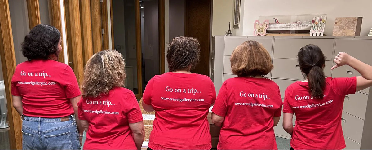 Five people standing with their backs to the camera wearing matching red t-shirts with white text that reads 'Go on a trip.