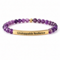 A beaded stretch bracelet featuring purple amethyst beads, a small gold spacer bead, and a polished gold-toned metal bar engraved with the words 'Unstoppable Resilience'.